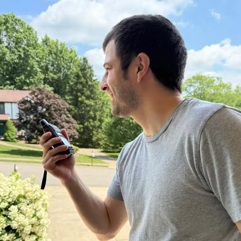Person using OKRADI G86 push-to-talk radio outdoors
